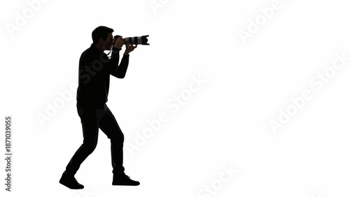 Silhouette of a photographer holding a camera and taking a picture.