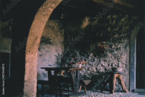 Wooden Table in front of an Ancient Stone House in Cornello dei Tasso Village, Italian Alps, during Late Summer. Beautiful Atmosphere. Camerata Cornello, Bergamo Province, Italy. Film Photography