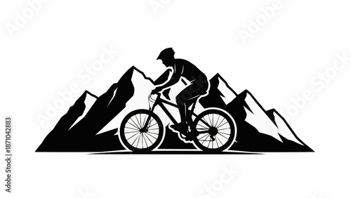 Mountain biker silhouette riding in front of jagged peaks.