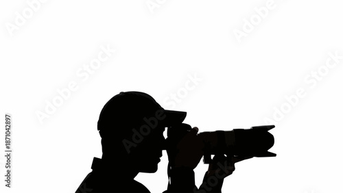 Silhouette of a photographer holding a professional camera and shooting.