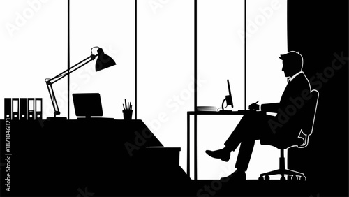 Silhouette of a businessman sitting at his desk in a modern office.