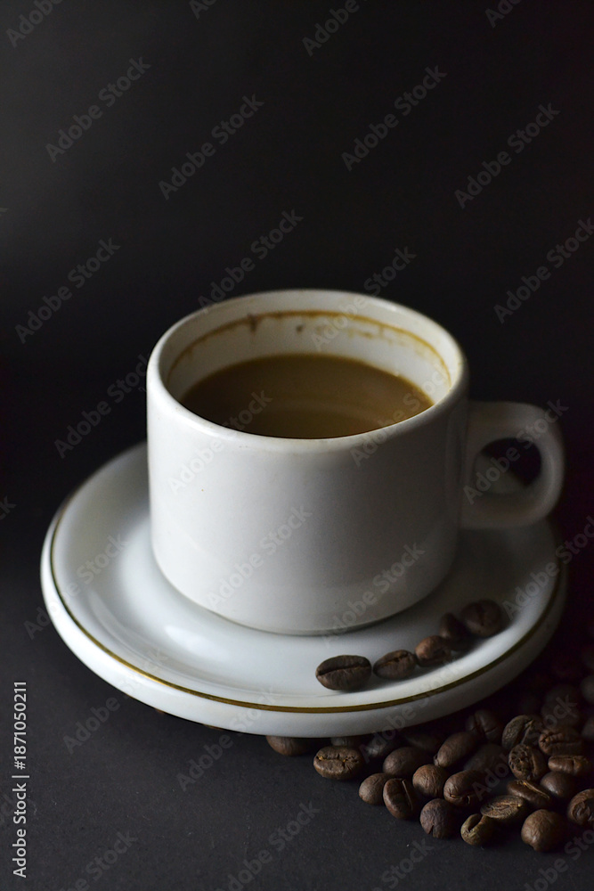 Fototapeta premium Cappuccino and coffee beans on a table with a dark background 