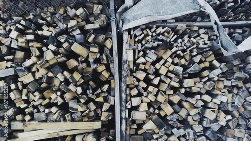 Winter background, chopped firewood stacked together and it is snowing,horizontal video