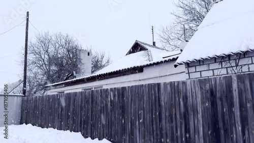 Snowflakes falling down slowly in the yard in winter, horizontal video