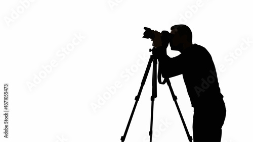 Silhouette of a photographer using a tripod and camera.