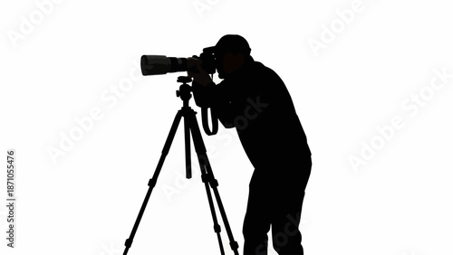 Silhouette of a photographer with a large lens on a tripod.