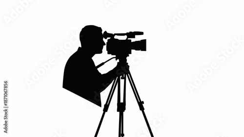 Silhouette of a cameraman operating a professional video camera on a tripod.