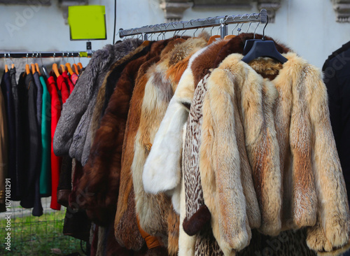 colorful second hand fur coats hanging on clothing rack