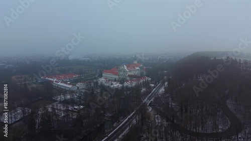 Cinematic drone footage of Kloster Fuerstenfeld. A cultural heritage site in Southern Germany. The monastery from above shows a misty drone shot of the historic complex in the Alpine foreland