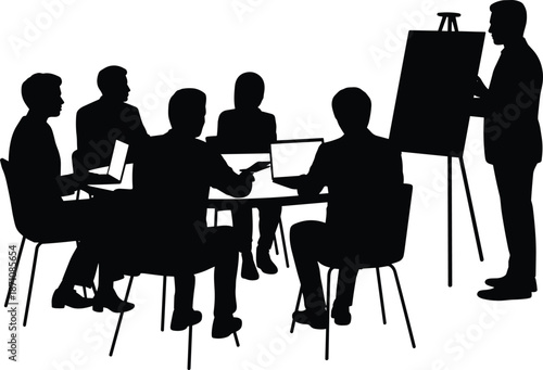 Group of people sitting around a table in a meeting with one person standing by a flip chart chairs