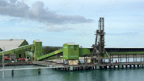 Port facility located by the water with loading equipment in action during daytime