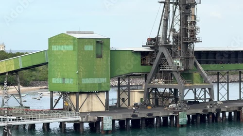 Port facility located by the water with loading equipment in action during daytime