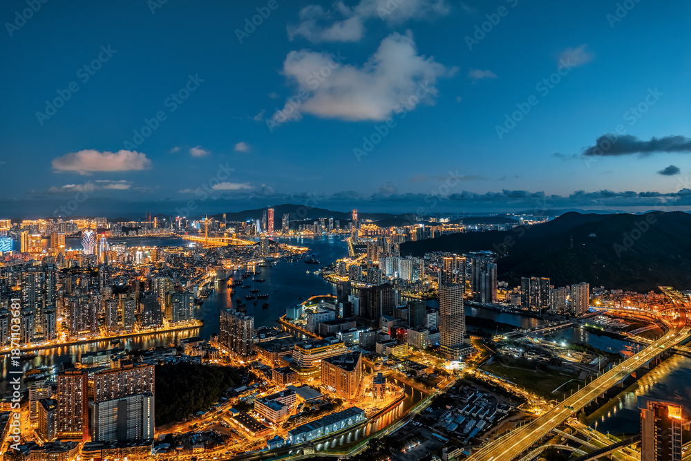 Fototapeta premium Aerial view of the vibrant city skyline and harbor at night in Macau.