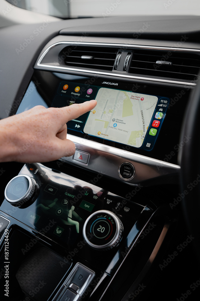 Naklejka premium Hand using Apple CarPlay touchscreen inside modern car