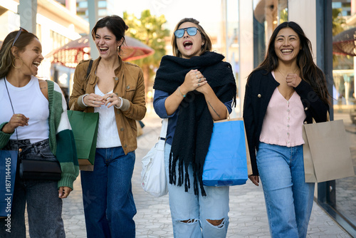 Group of young women friends happily shopping