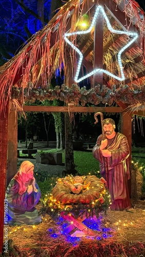 Illuminated Nativity scene at night. Christmas scene with figures representing the birth of the baby Jesus Christ in the manger.