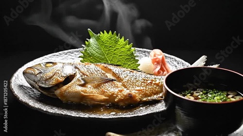 Whole fried fish on a dark plate, golden skin, steam rising, green leaf garnish, side sauce. Richly