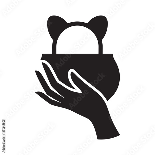 A hand gently cradling a rounded object with two small ear like shapes
