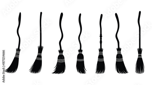 A collection of black witch brooms displayed in striking silhouette