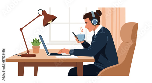 Young man wearing headphones working on his laptop while holding a smartphone and a hot cup of coffee at a desk by a window.