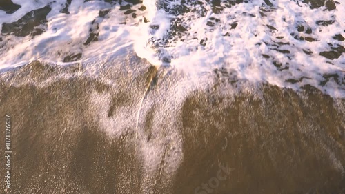 夕暮れの砂浜と打ち寄せる波の俯瞰イメージ
