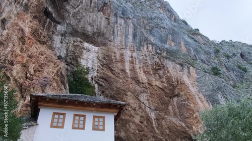 Handheld bottom up panning footage of The Blagaj Tekija, historic Sufi monastery and dervish house built on the cliffs by the Buna river in Mostar, Bosnia and Herzegovina