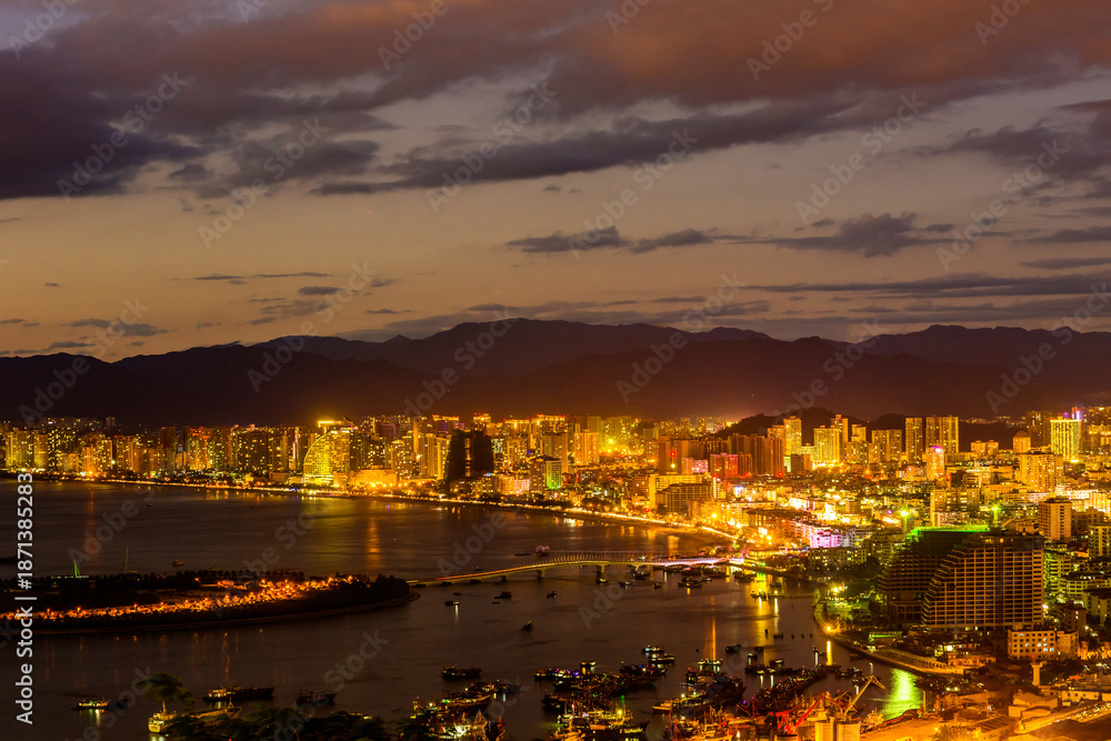 Fototapeta premium Sunset view of Sanya town with city lights. View from Luhuitou Park on Hainan Island of China.