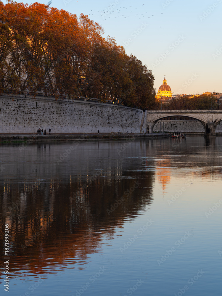 Obraz premium Tiber River with Autumn Trees and St Peter’s Basilica at Sunset
