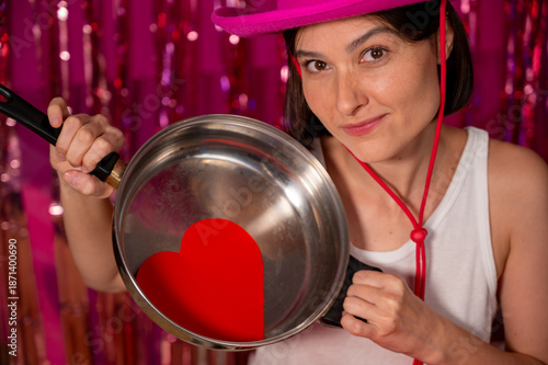 Foto A Valentine's Day heart on a frying pan in a girl's hands