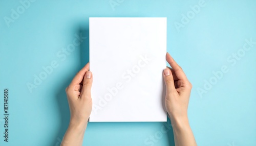 Hands holding a blank white paper on a blue background.