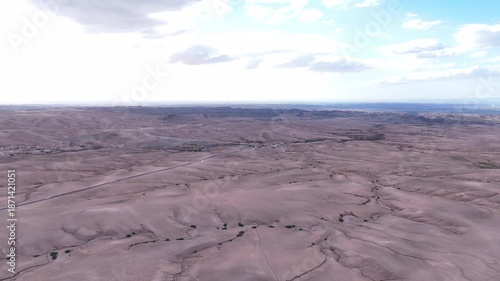 aerial cracked desert plain showing fissures, dry gullies and textured earth geologist surveyor conducting fieldwork, capturing