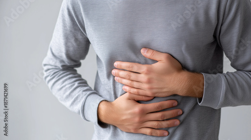 Man holding his stomach in pain, symbolizing abdominal discomfort, illness, and digestive health issues.
