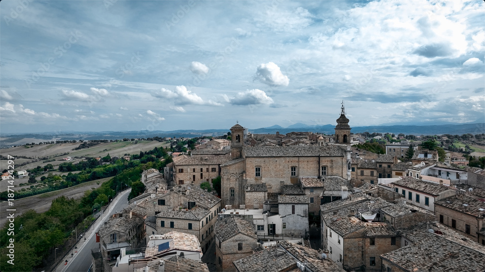 Obraz premium Drone aerial view of a historic Italian town with traditional architecture. Urban landscape surrounded by countryside under clear sky.