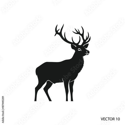 A majestic stag stands proudly with its large antlers in a serene forest, viewed from the side.
