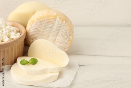 Different dairy products and basil on white wooden table, closeup. Space for text © New Africa