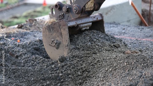 Excavator digging into gravel fill