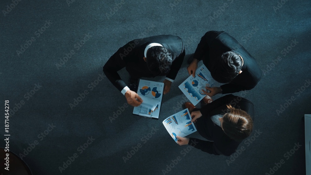 Naklejka premium Top view of skilled businessman handed out financial paper to manager. Professional marketing team talking about marketing idea while receive and look at stock market investment chart. Directorate.