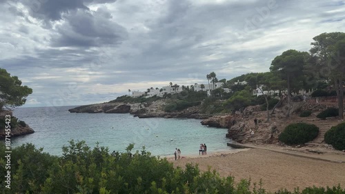 Cala Esmeralda beach in Cala d'Or village on Mallorca island in Spain. Beatuful bay with many white villas and green plants growing on the seaside