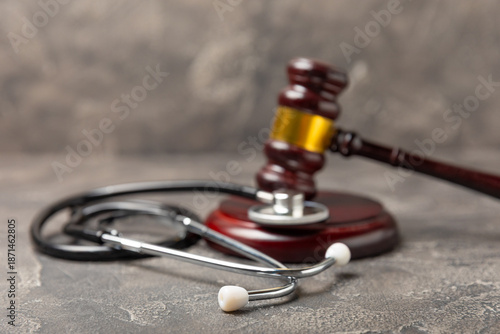 A stethoscope and hammer on a desk. Medical malpractice, personal injury lawyer, and healthcare legal aspects concept.Lawyer.Legal definition of medical negligence. Law concept.Healthcare and Medicine