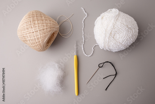 Fotografie Crochet tools and materials with yarn balls, stuffing fiber, hook and needle on a neutral background