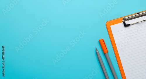 Orange Clipboard with Pen and Marker on Blue Background For Taking Notes