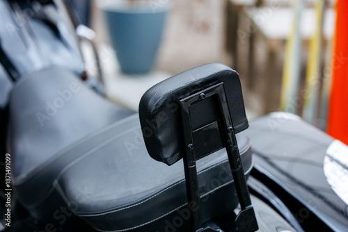 Canvas Print Black leather motorcycle seat with backrest on outdoor motorbike