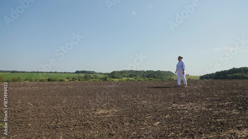Woman farmer walking on plowed field