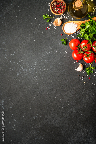 Food background with fresh vegetables, herbs and spices on black. © nadianb