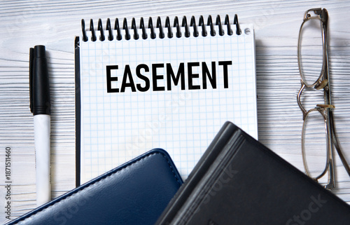 Photos EASEMENT - word in white paper on the background of a diary, glasses and pen