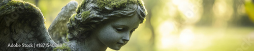 Moss covered stone angel statue in garden with soft sunlight close up