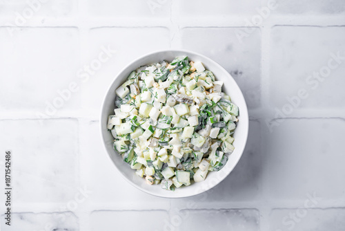 Cucumber egg mayonnaise salad in a bowl on a white background