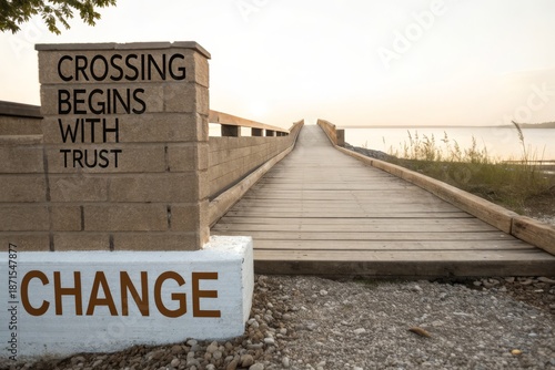 Wooden boardwalk leading to the ocean at sunset, with a brick pillar bearing a message of change