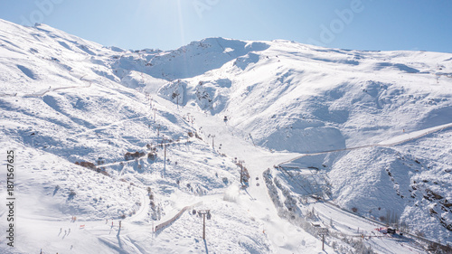 Aerial photo from dronet to Sierra Nevada ski resort on a sunny winter day in the mountains, Spain. Sierra Nevada is the largest mountain range near the city of Granada in Spain with snow. Sierra Neva