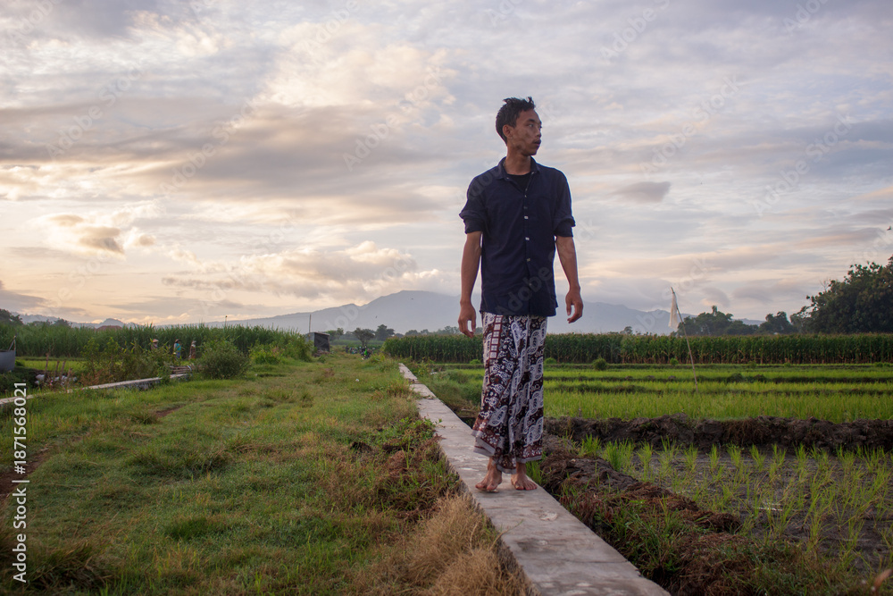 Fototapeta premium Mindful Meditation by a Javanese Youth Wearing a Batik Sarong